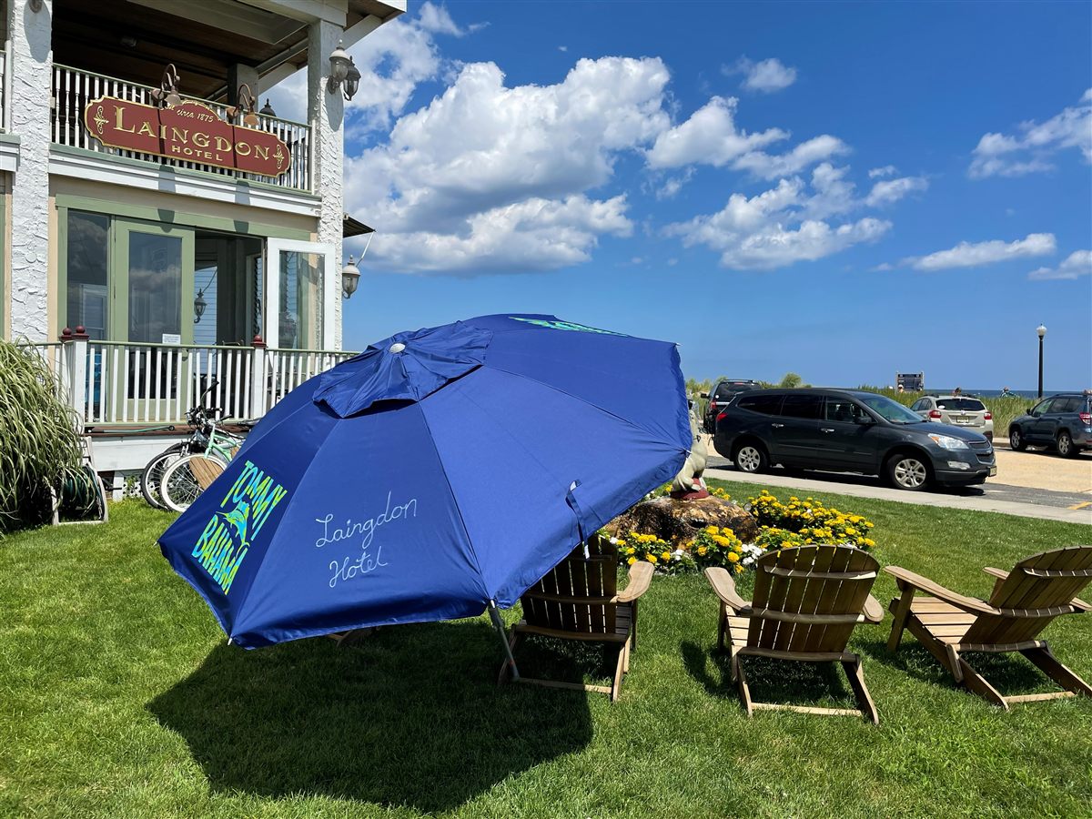Front lawn with Adirondack chairs and a Laingdon Hotel umbrella, steps from the Ocean Grove beach